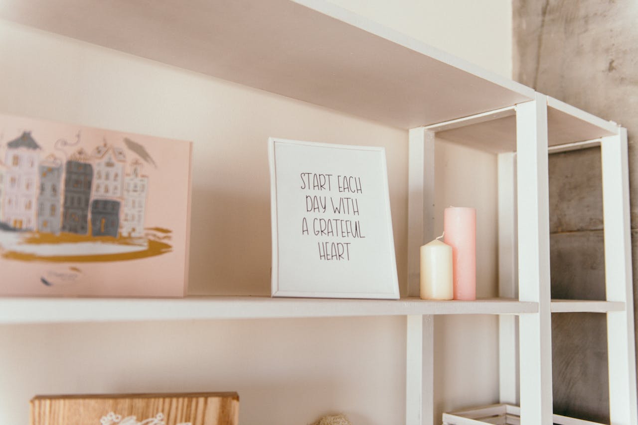 story-01 Stylish white shelf with candles and an inspirational quote frame for modern interior decoration.